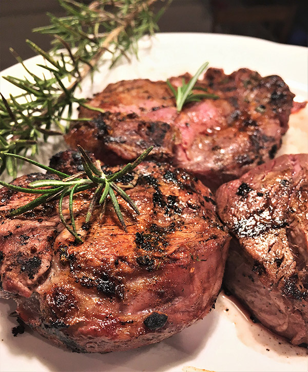 steaks garnished with rosemary